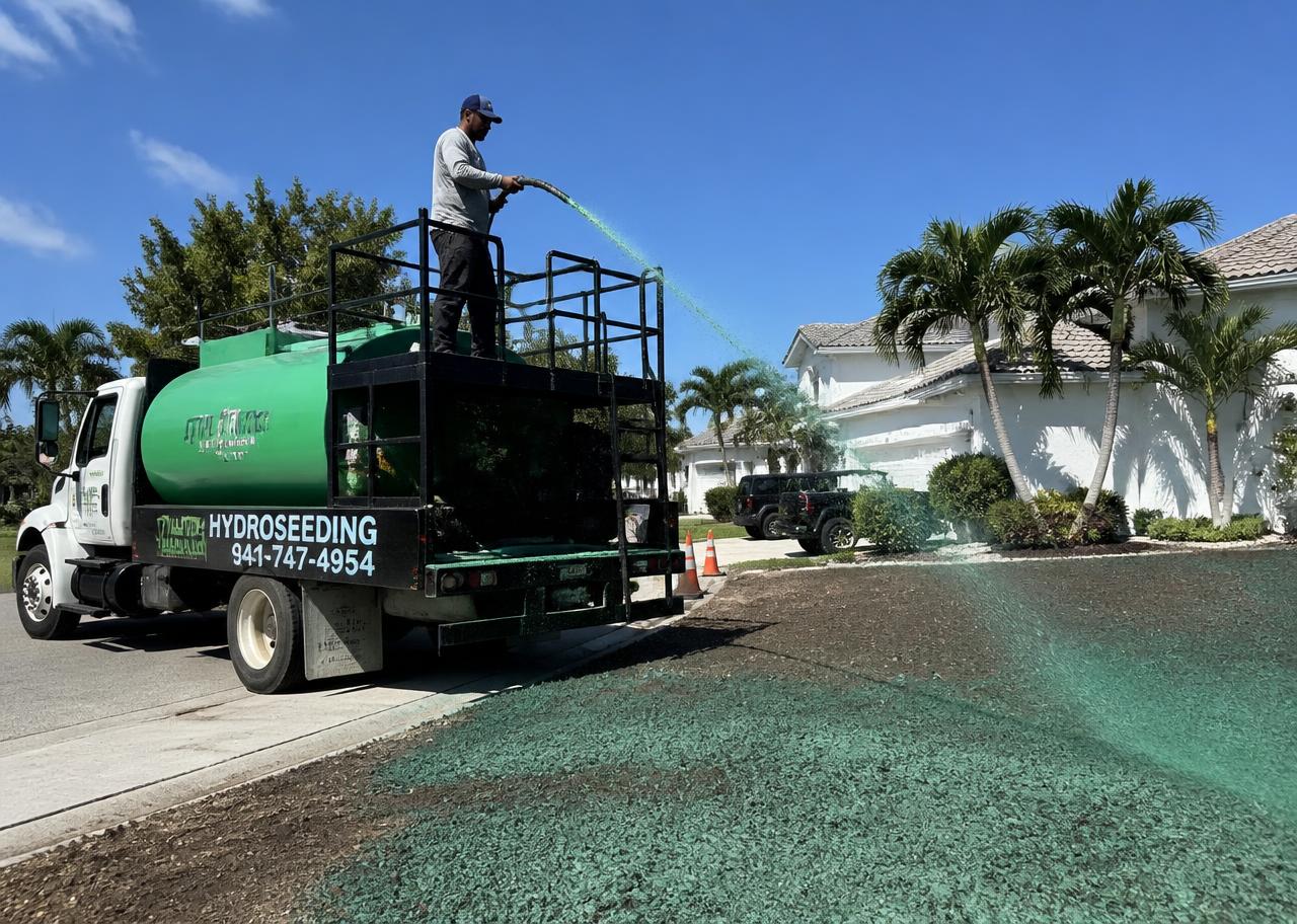 Hydroseeding truck applying green slurry over a prepared residential lawn area in Florida